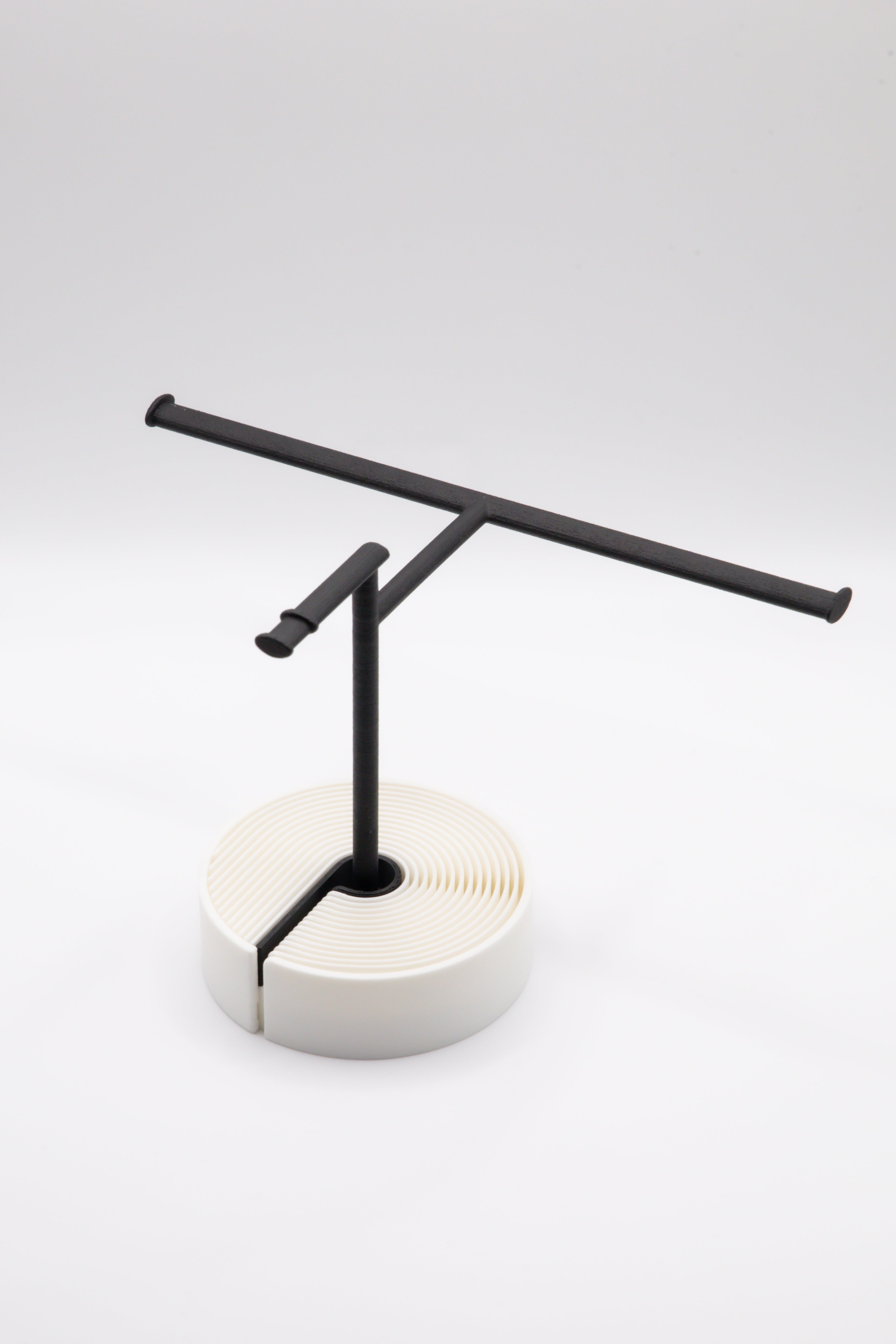 Brillenhalter PureStand in Schwarz matt mit runder weisser Base und schwarzem Einlegeteil.