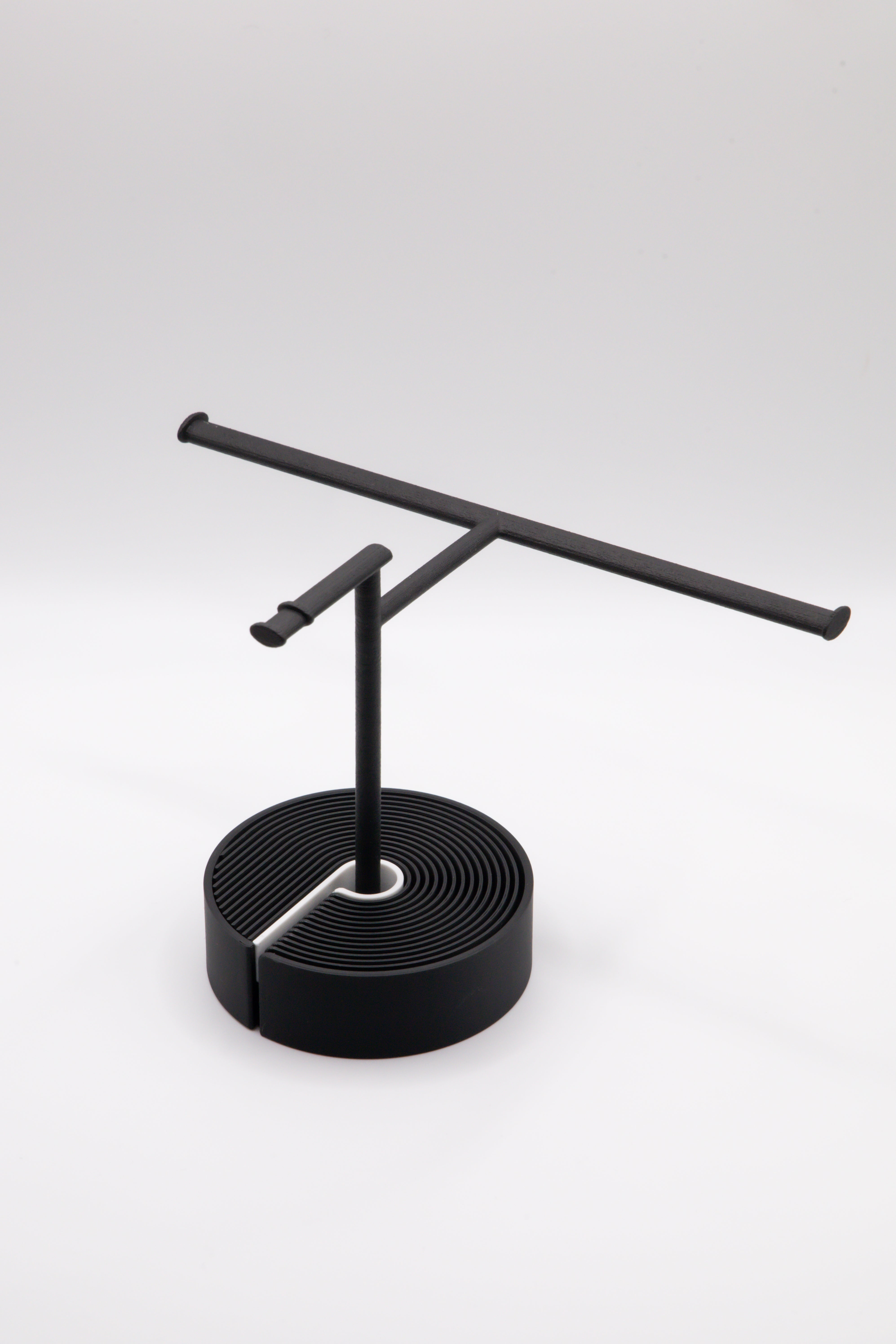 Brillenhalter PureStand in Schwarz matt mit runder schwarzer Base und weissem Einelegeteil.