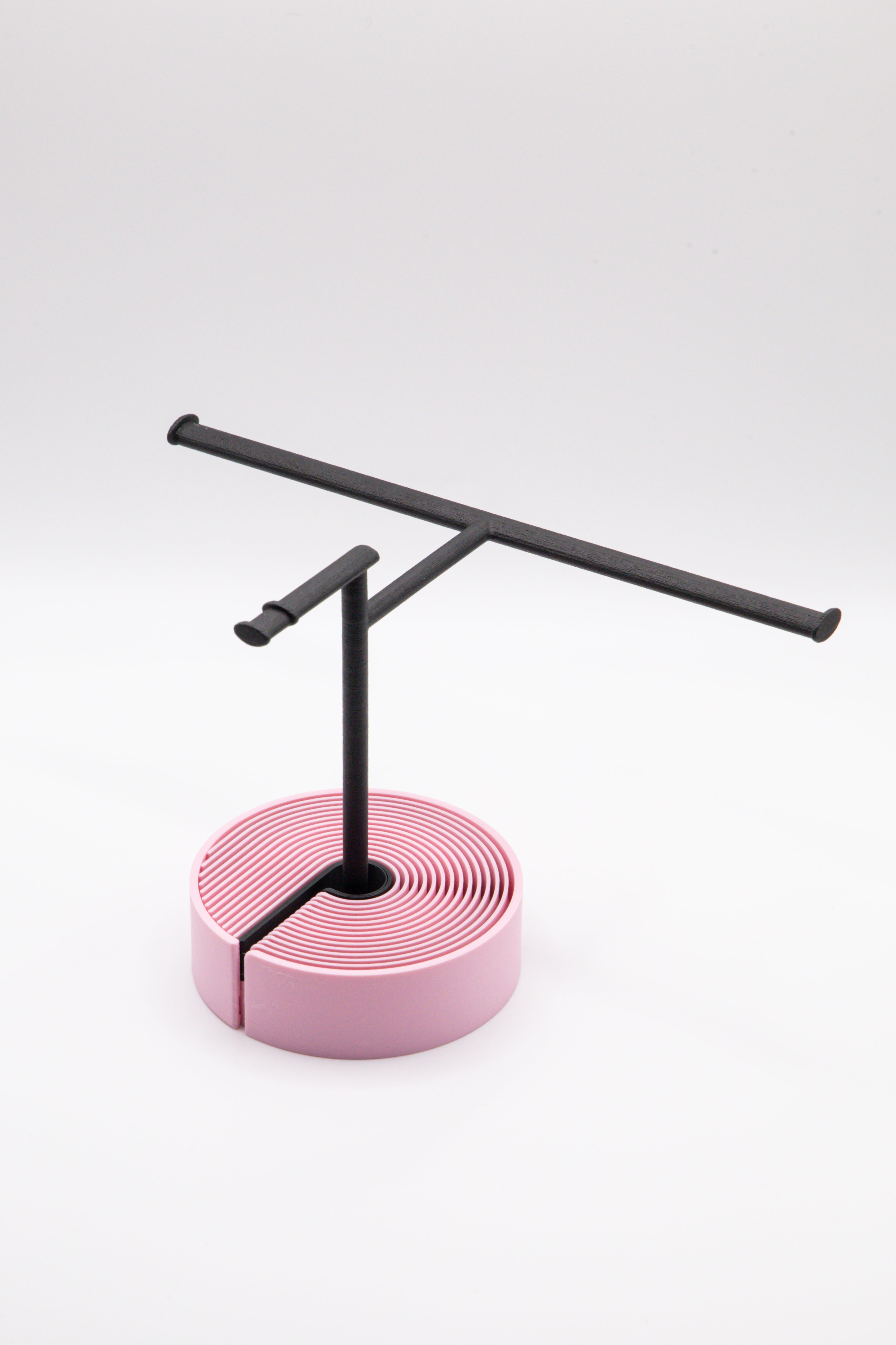 Brillenhalter PureStand in Schwarz matt mit runder pinker Base, und schwarzem Einlegeteil.