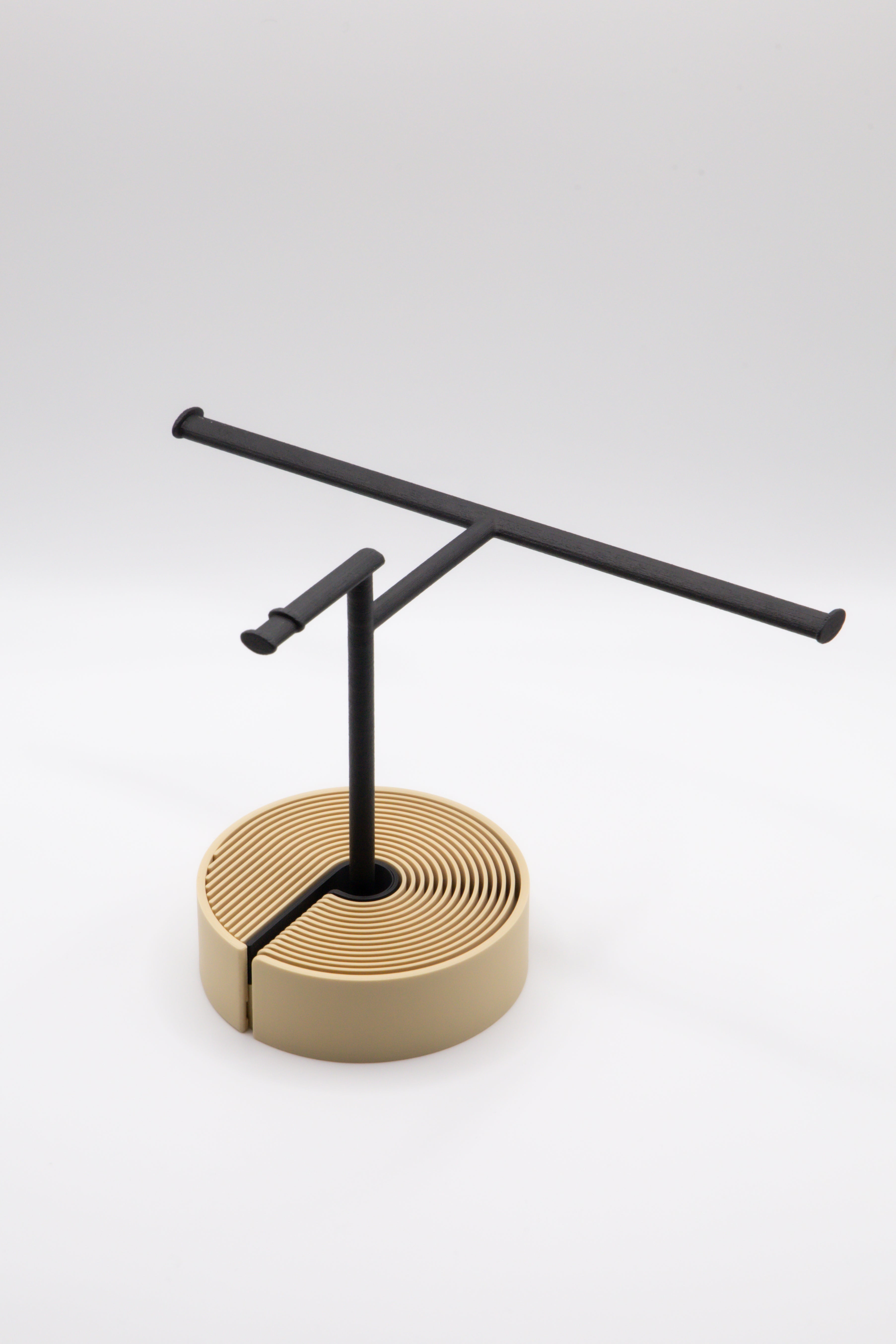 Brillenhalter PureStand in Schwarz matt mit runder beiger Base und schwarzem Einlegeteil.