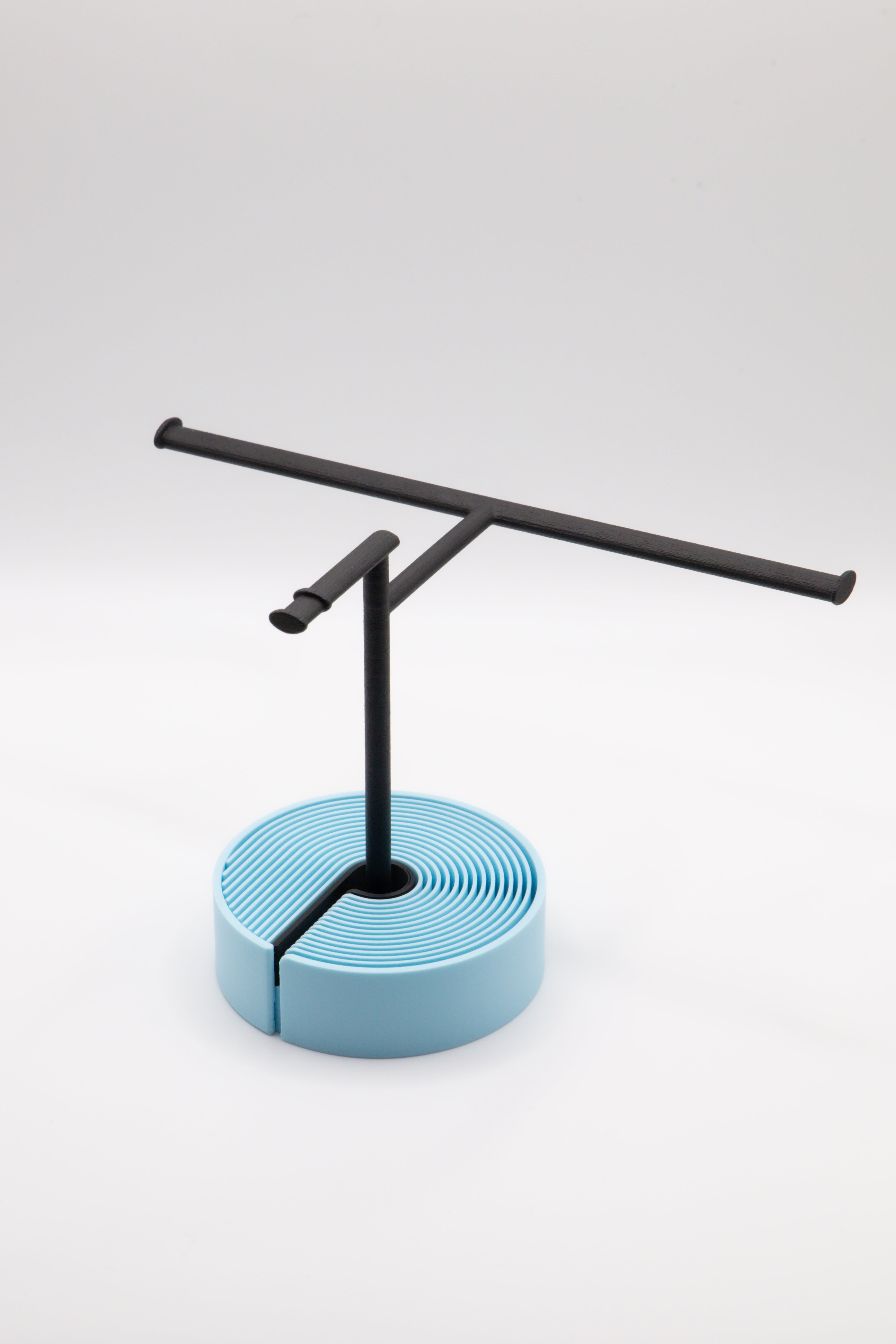 Brillenhalter PureStand in Schwarz matt mit runder blauer Base und schwarzem Einlegeteil.