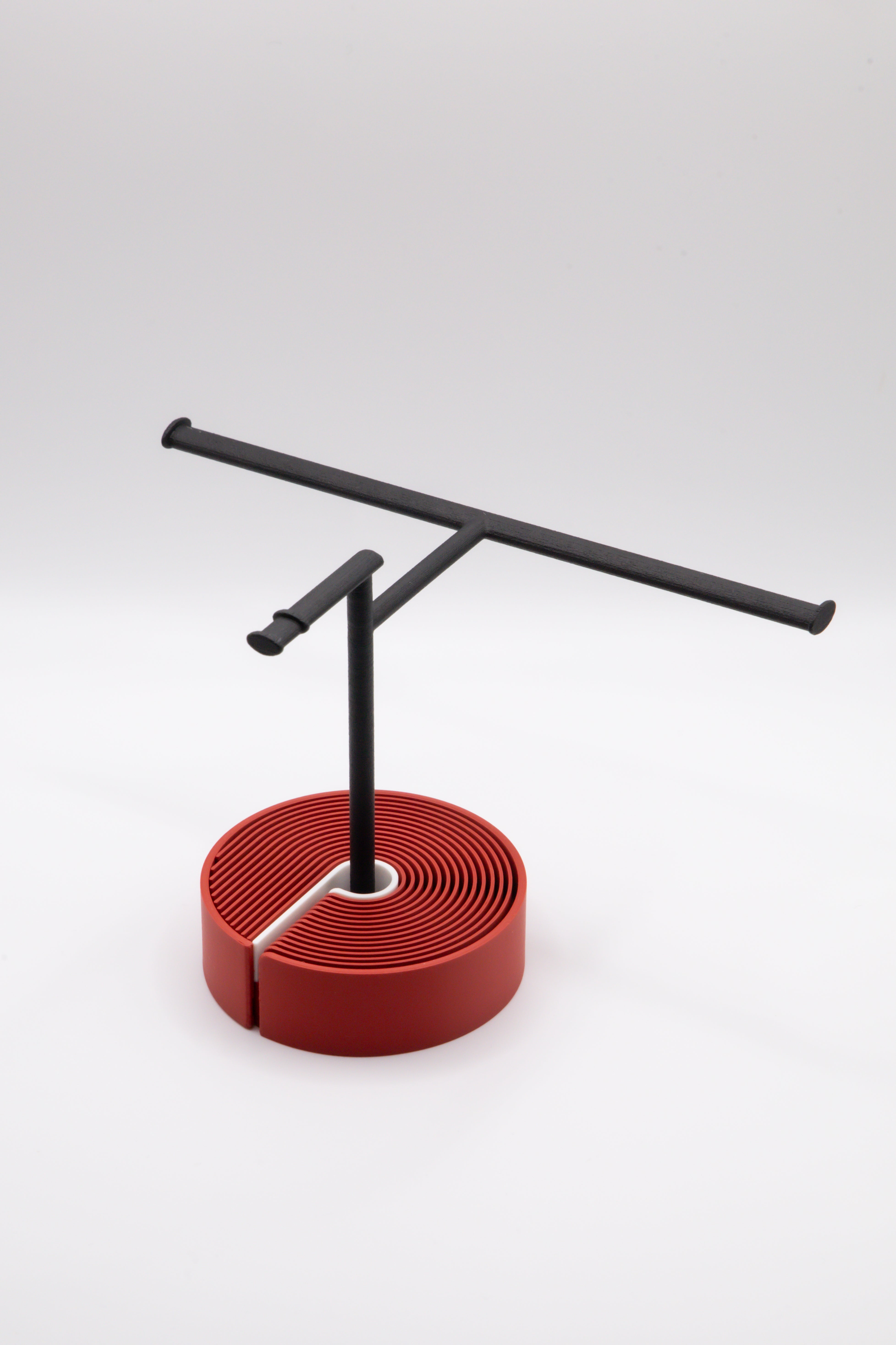 Brillenhalter PureStand in Schwarz matt mit runder roter Base und weissem Einlegeteil.